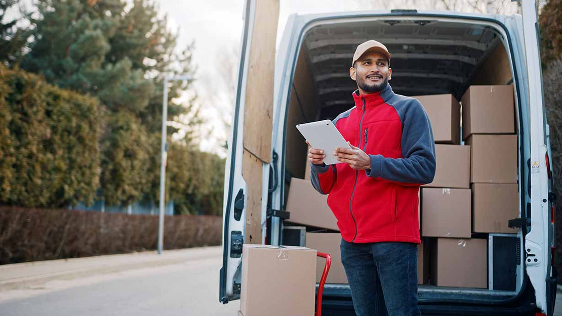 Paketbote steht vor Lieferwagen